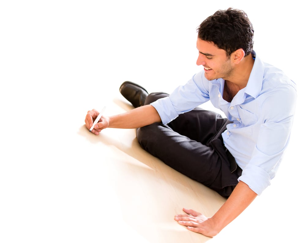 Business man writing on the floor with a marker - isolated over white
