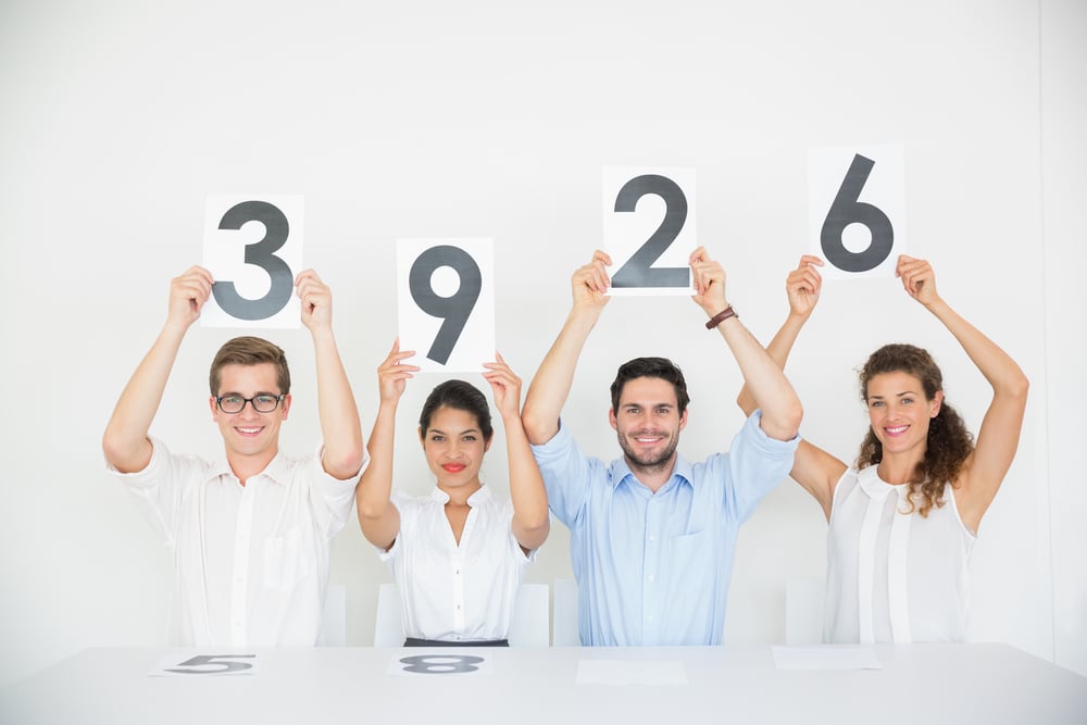 Portrait of panel judges holding score signs in office