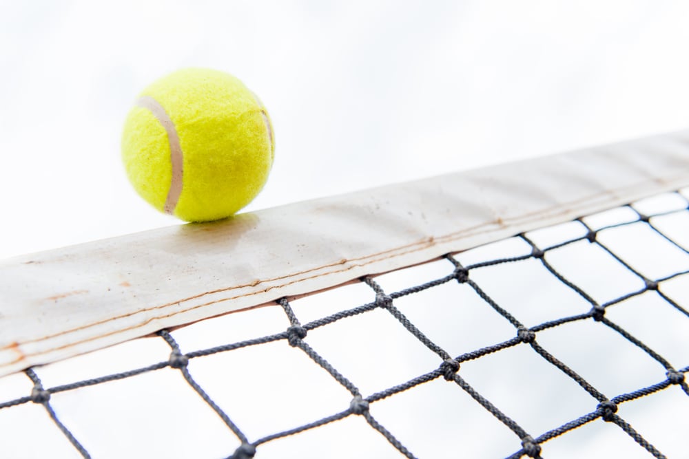Tennis ball hitting the net - isolated over white