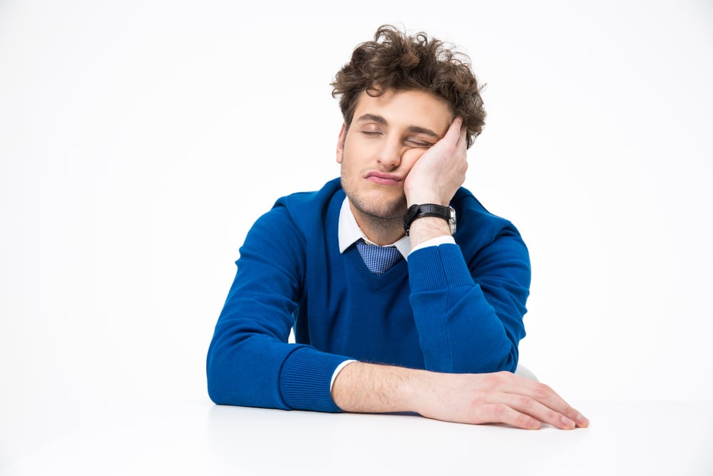 Tired businessman sleeping at the table over white background